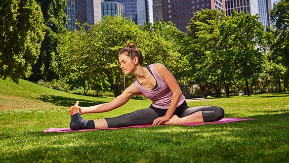 "Woman stretching on a yoga matt showcasing her medi ankle support "
