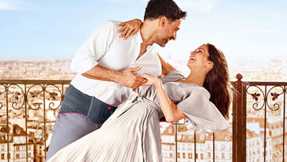 Happy couple dancing on a rooftop showcasing the mans lumabmed back support