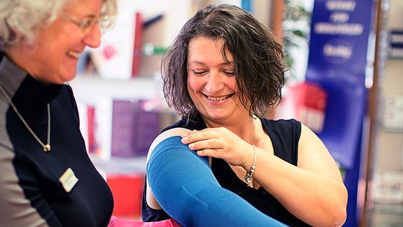 Lipoedema patient Brigitte trying on a new blue medi compression arm sleeves