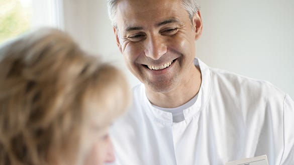 Diabetes specialist smiling brightly at his patient  during her appointment