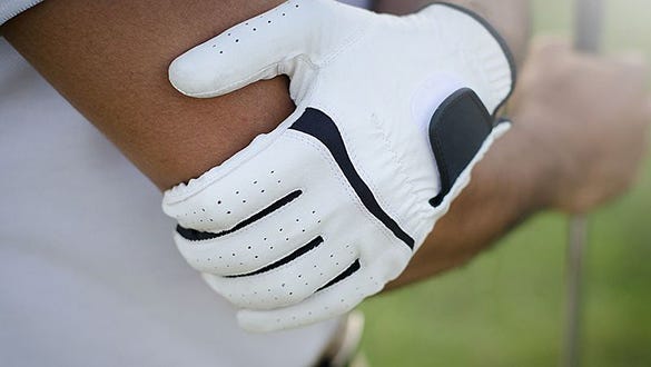 Person wearing a  white golf glove helping to prevent her from dislocation