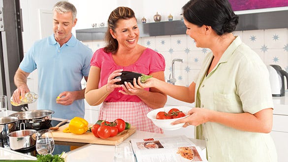 Three people enjoying cooking a  nutrious and delicious  meal together while maintaining their healthy diet
