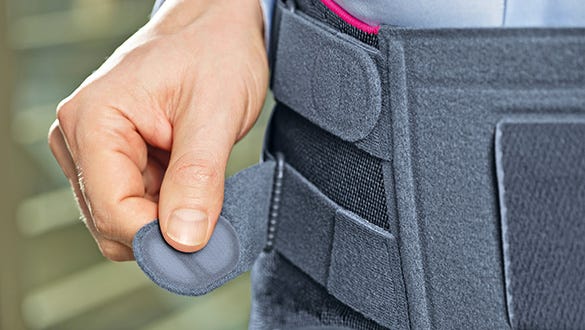 Close up shot of the medi lumbamed back belt being put on on a male body