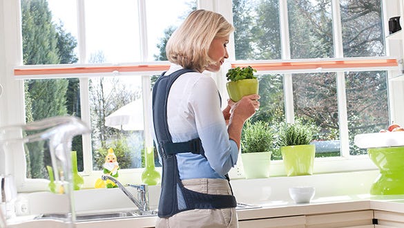 Woman wearing a medi back support to fight against her osteoporosis