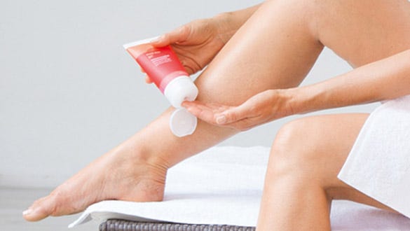 Woman puttitng medi skincare on her  hand ready to apply the cream to her legs