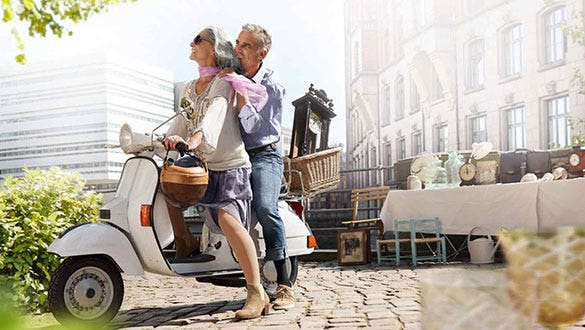 elderly couple enjyoing their vespa ride through an italien city at risk of travellers thrombosis