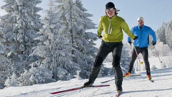 two men going skiing in the snowy mountains despite travelling with an injury