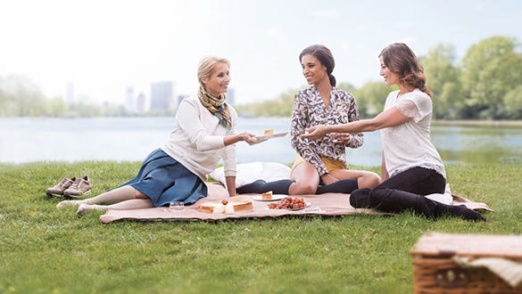 three woman wearing medi compression stockings having picnic on the lakeside
