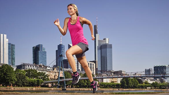 Woman running  fast along the Frakfurt main skyline