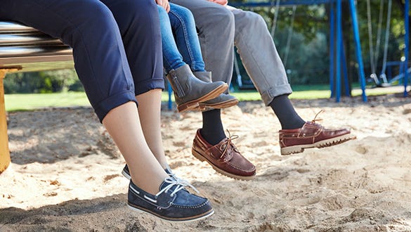 cut off family sitting on a bench  dangeling their legs, the parents wear compression stockings