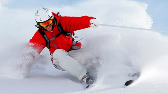 man in his winter gear going wildly  skiing in a dangerous deep snow environment