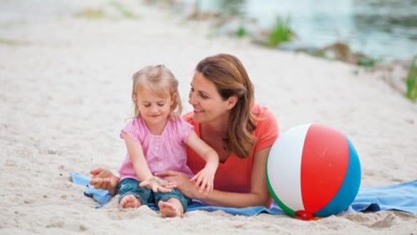 mother spending time with her daughter at the beach while they are on their holiday together 