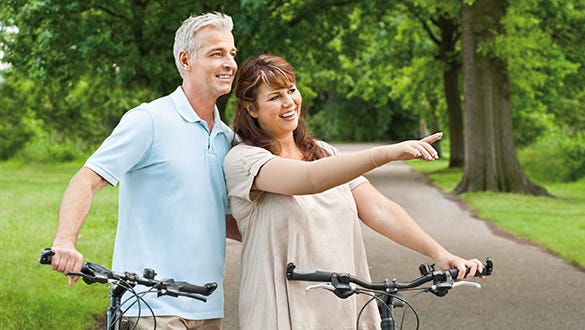 Couple stopping during their bike tour to point at something exciting.