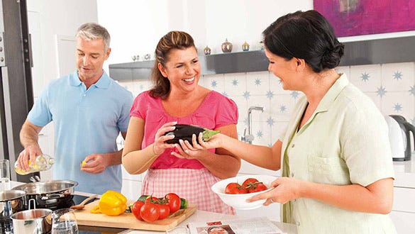 Three people enjoying cooking a nutrious and delicious  meal together while maintaining their healthy diet