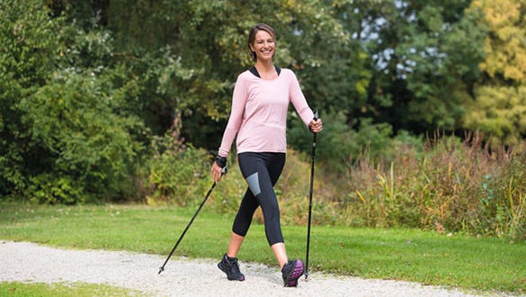 "A woman goes nordic  walking to maintain  her healthy back despite her office job