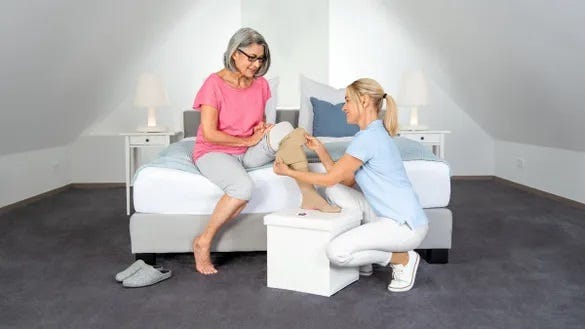 woman needing help to put on her elastic garmets because she has a wound on her leg